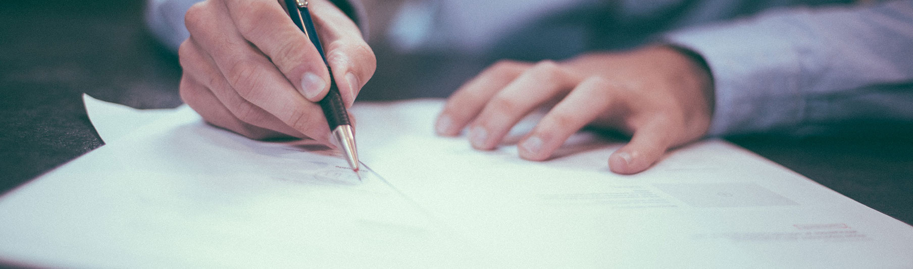 Claims: Close-up of hands writing on sheets of detailed notes