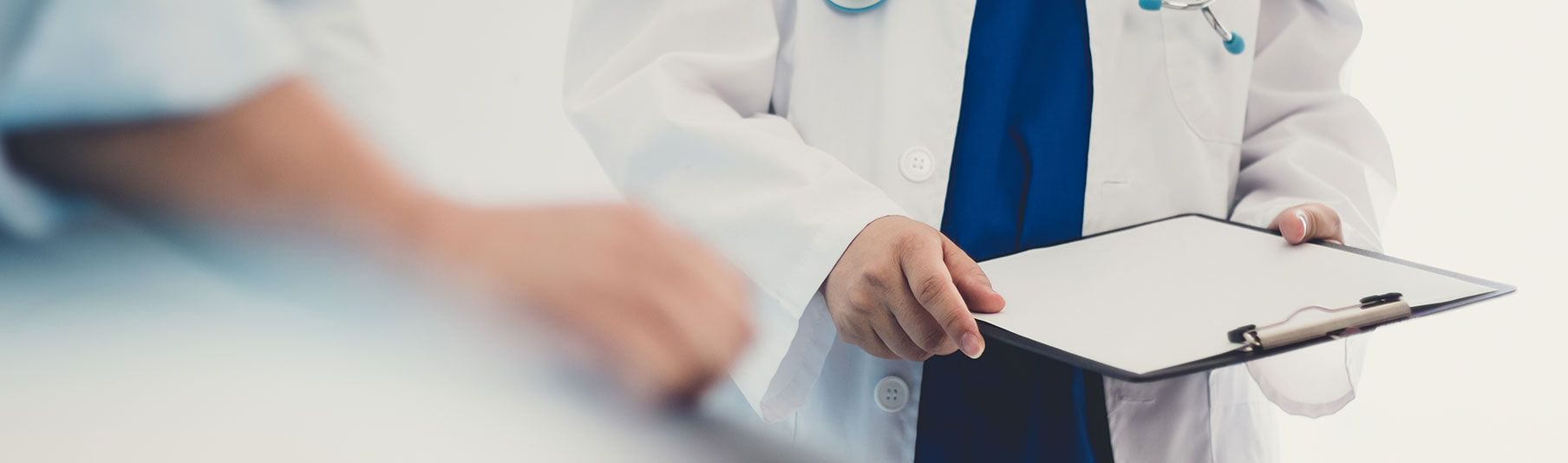 Locum Insurance: A doctor holding a clipboard infront of a patient