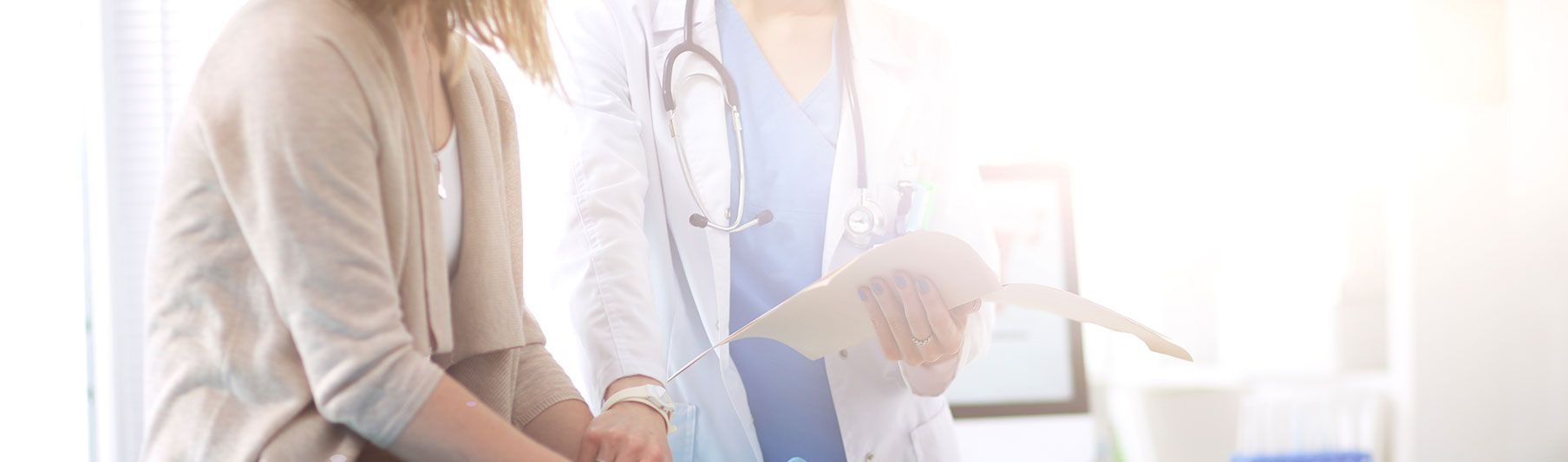 Locum Insurance Buyers Guide: A doctor checking a file while supporting a patient